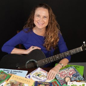 Johnette w books and guitar 2016
